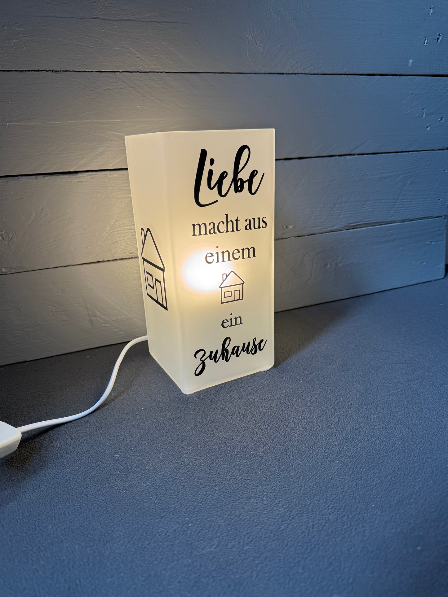 Detail des Spruchs „Liebe macht aus einem Haus ein Zuhause“ auf Glaslampe