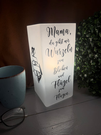Beleuchtete Mama-Glaslampe mit Spruch über Wurzeln und Flügel.