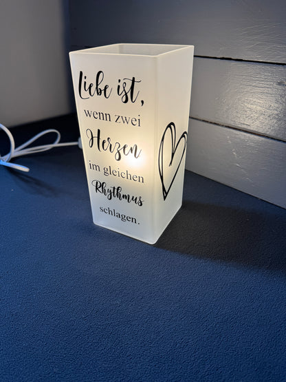 Detail des Schriftzugs „Zwei Herzen im gleichen Rhythmus“ auf Glaslampe mit Vinylbeschriftung