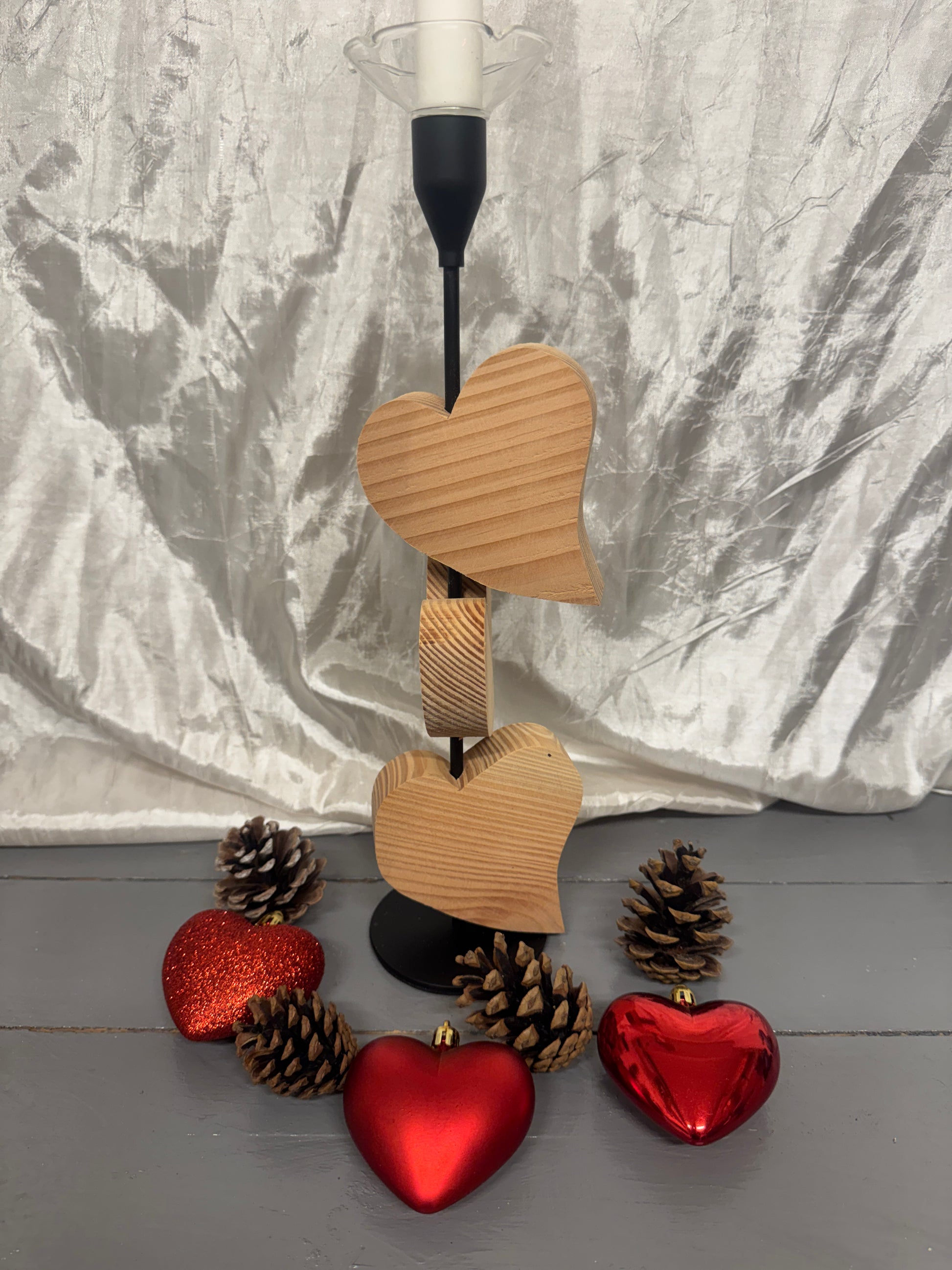 Detailansicht des Kerzenständers „Herzensglück“ mit drei beweglichen Herzen aus Lärchenholz und Metallgestell.