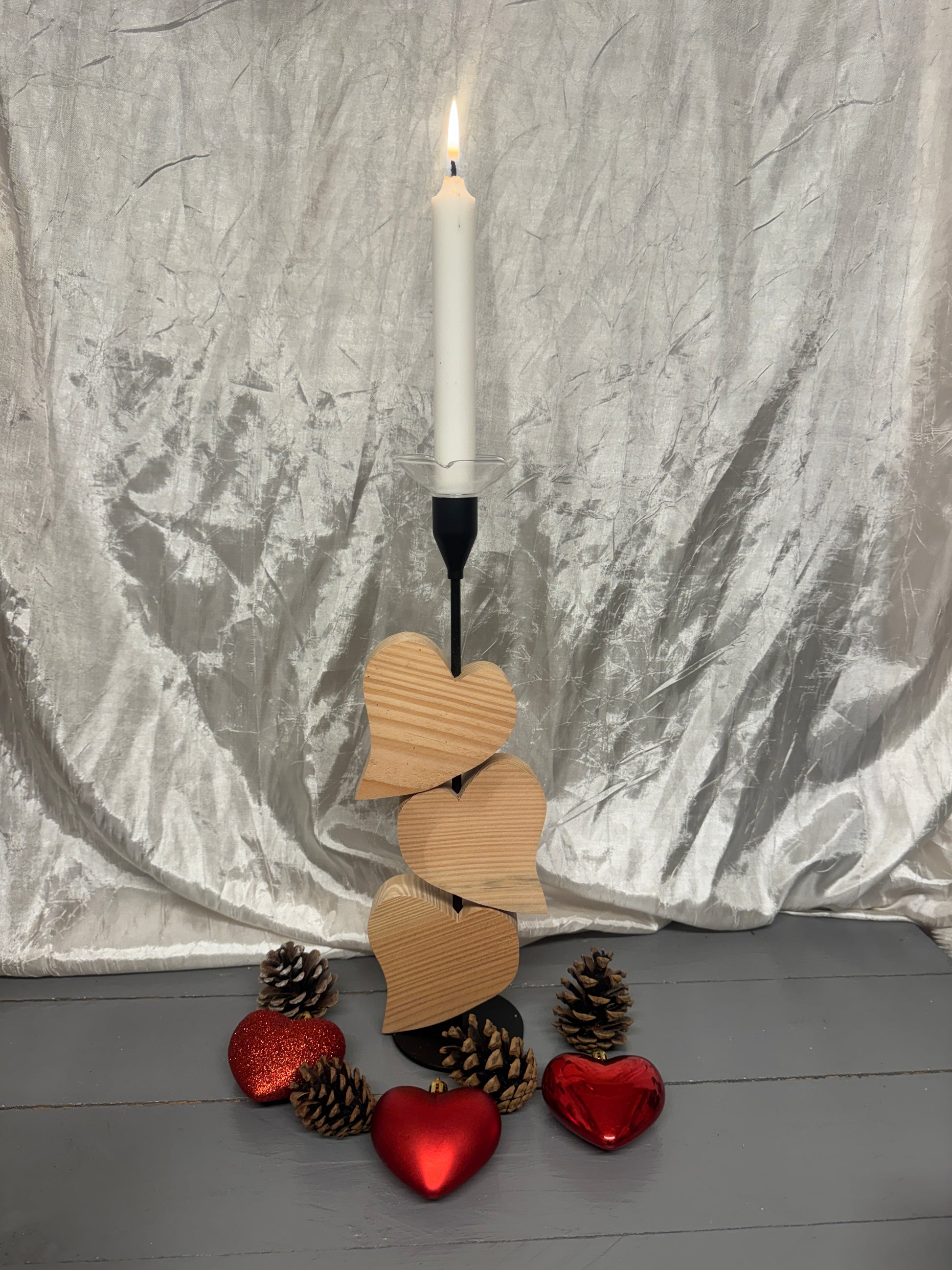 Kerzenständer „Herzensglück“ aus Metall mit drei beweglichen Herzen aus Lärchenholz – Vorderansicht mit Tropfschutz aus Glas.