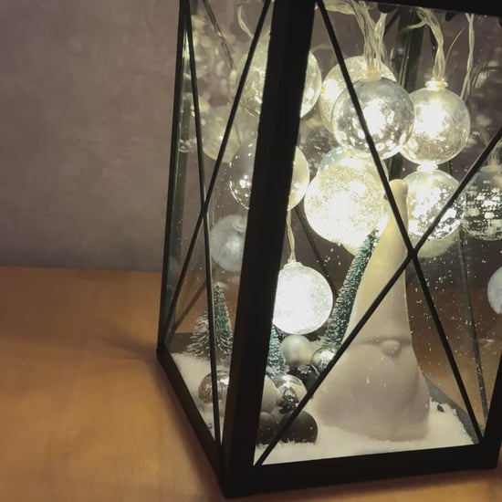 Video zeigt die handgefertigte Weihnachtslaterne mit LED-Lichterkette, glitzernden Kugeln und Wichtelfigur in stimmungsvoll leuchtender Winterlandschaft.