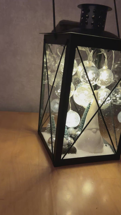Video zeigt die handgefertigte Weihnachtslaterne mit LED-Lichterkette, glitzernden Kugeln und Wichtelfigur in stimmungsvoll leuchtender Winterlandschaft.