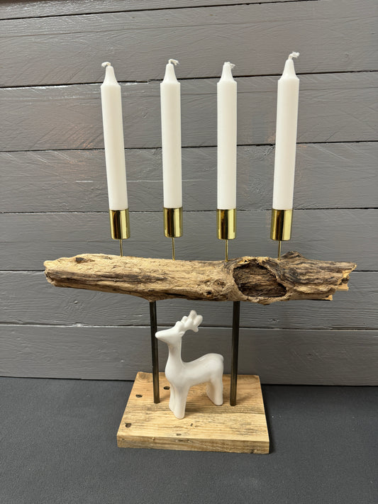 Handgefertigtes Treibholz-Adventsgesteck „Adventsfeuer Goldküste“ mit vier goldenen Stabkerzenhaltern auf geflammtem Holz – Vorderansicht.