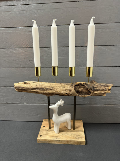 Handgefertigtes Treibholz-Adventsgesteck „Adventsfeuer Goldküste“ mit vier goldenen Stabkerzenhaltern auf geflammtem Holz – Vorderansicht.