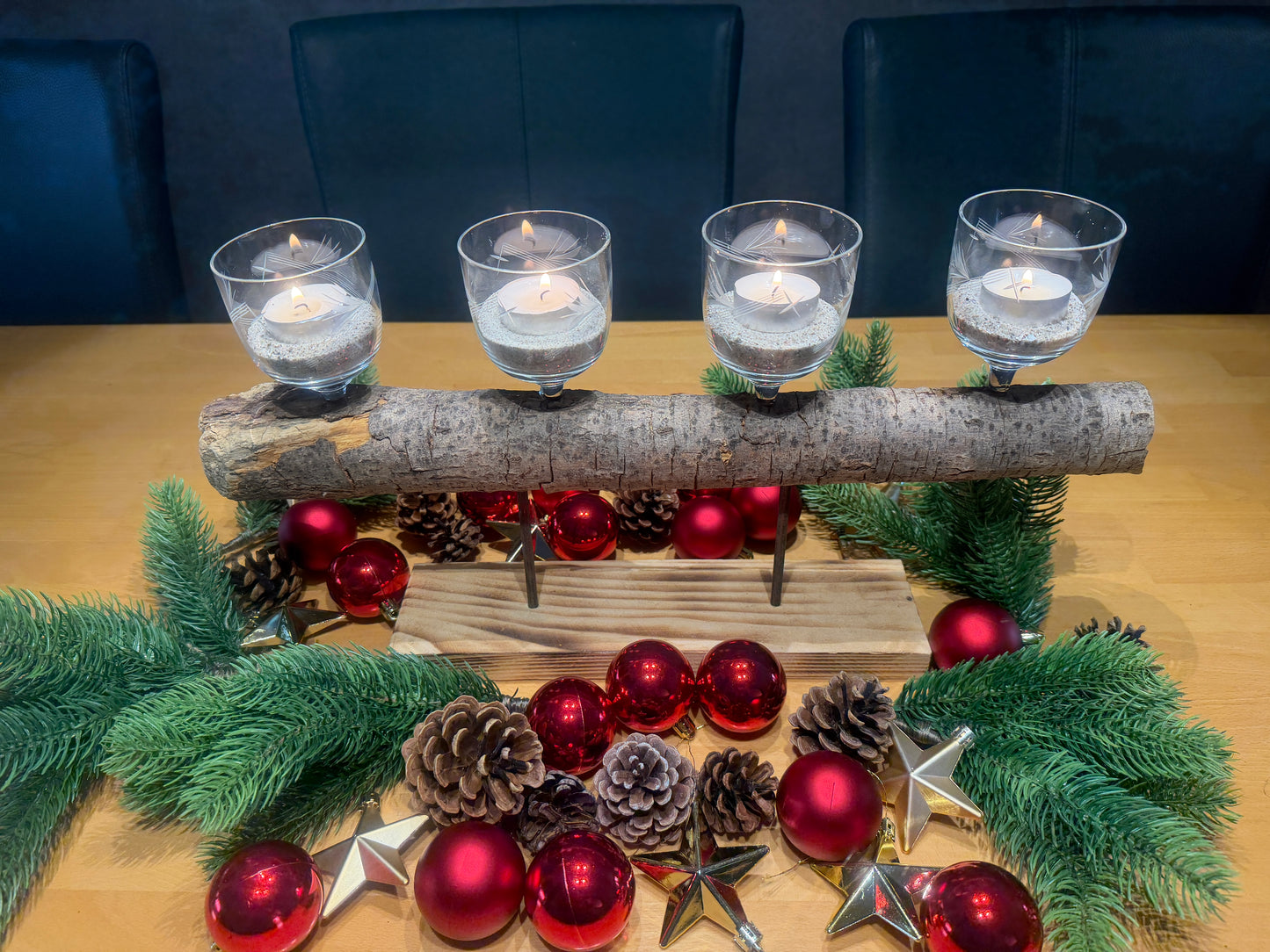 Handgefertigtes Adventsgesteck „Hafenfeuer“ aus Treibholz und Palettenholz mit vier Weingläsern für Teelichter, weihnachtlich dekoriert und leuchtend.