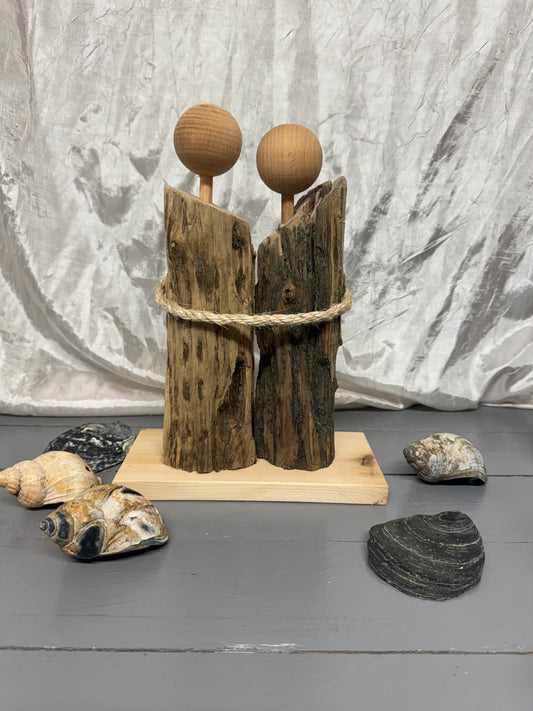 Handgefertigtes Treibholz-Liebespaar „Küstenliebe“ aus Nordsee-Treibholz von Eiderstedt auf Holzsockel – Vorderansicht.