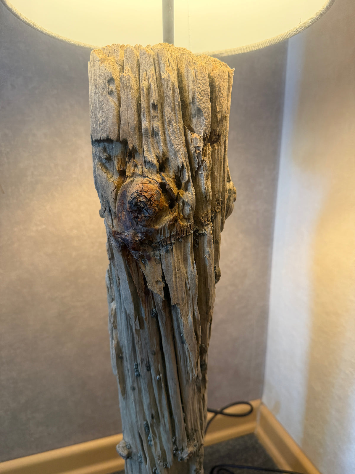 Detailaufnahme der verwitterten Holzstruktur einer handgefertigten Treibholz-Stehlampe aus Nordseeholz