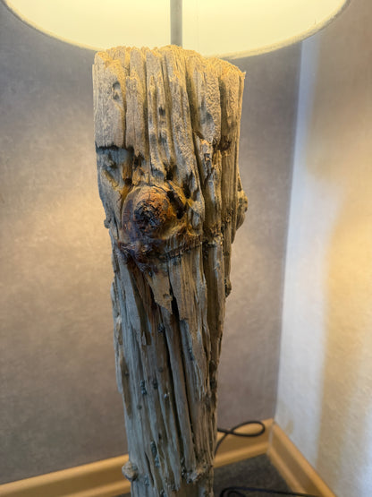 Detailaufnahme der verwitterten Holzstruktur einer handgefertigten Treibholz-Stehlampe aus Nordseeholz