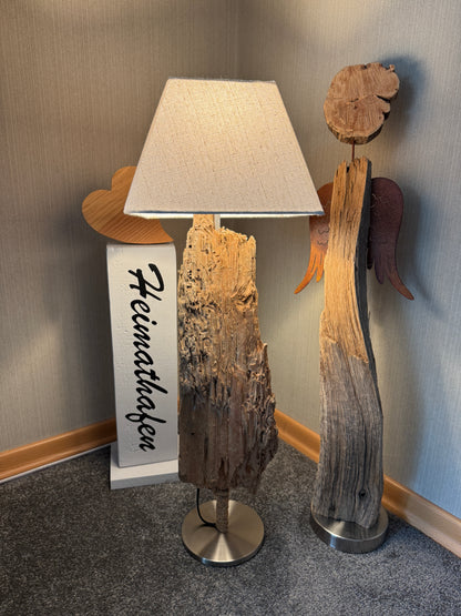 Ansicht der Treibholz-Tischlampe „Ostseelicht Muschelfund“ aus der Region Schwansen mit eckigem Lampenschirm in beige. 