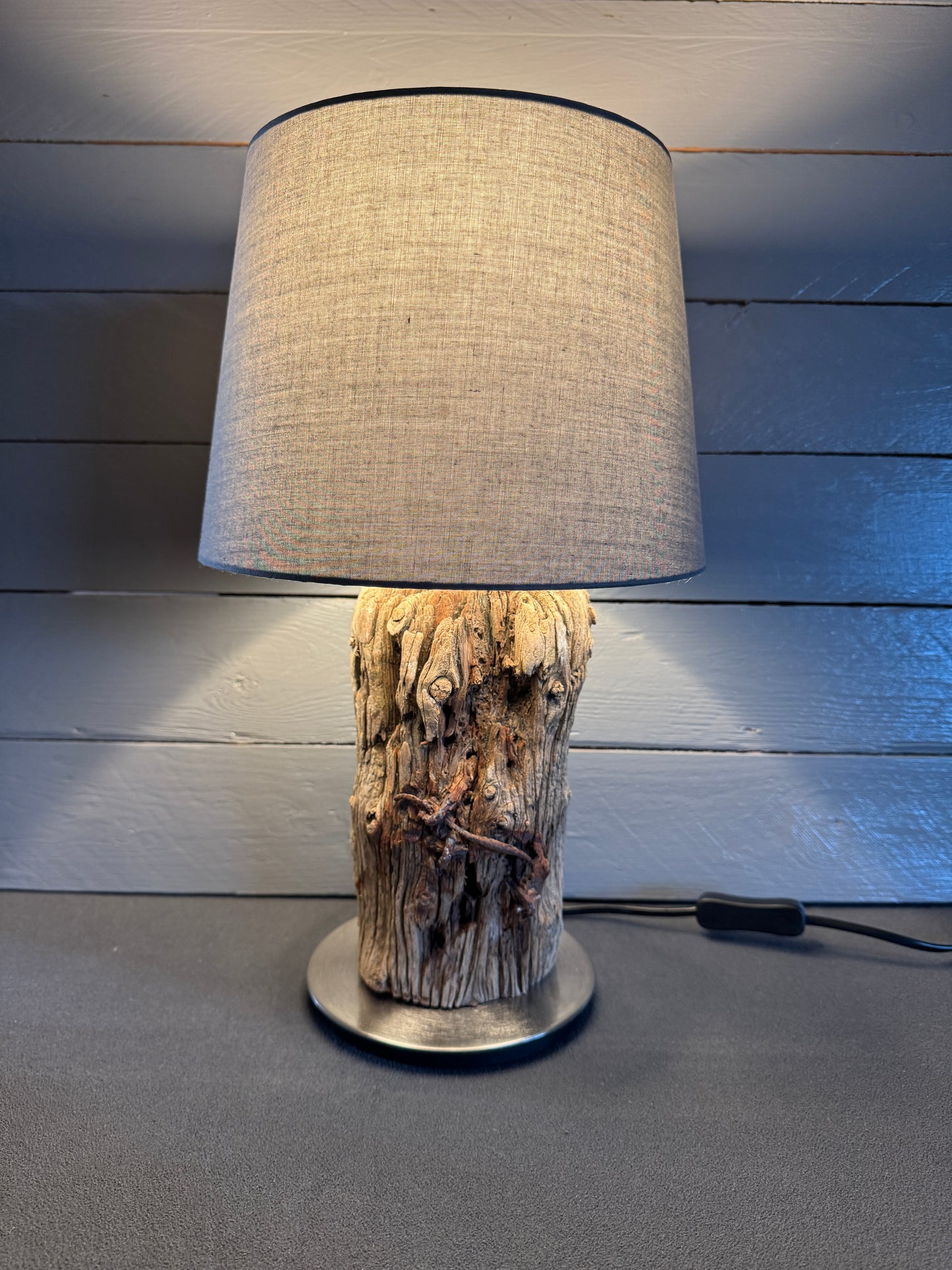 Treibholzlampe rund 24 cm Grau mit warmem Licht eingeschaltet
